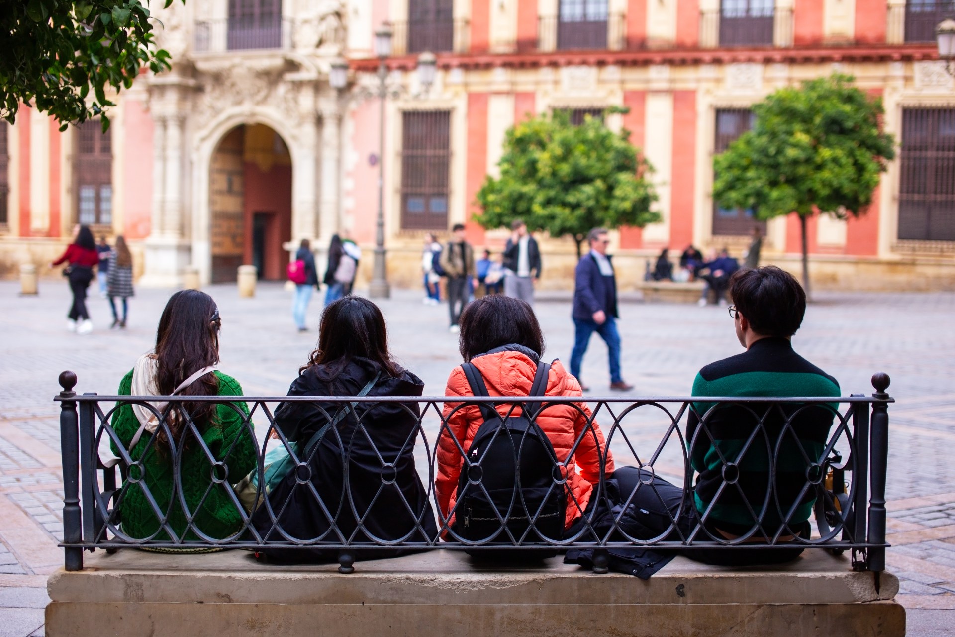 Students relaxing on a bench in a square in Seville